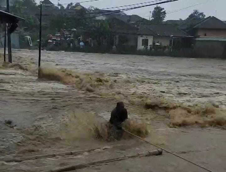 BENCANA BANJIR : Detik-detik warga saat melintasi banjir yang meluap dari sungai. (tangkapan layar)