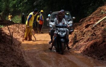 Kendaraan roda dua dan roda empat melintasi jalan yang sudah dibersihkan petugas pascalongsor di akses Jalan Raya Sigaranten, Kabupaten Sukabumi, Jawa Barat, Minggu (8/12/2024). (ANTARA FOTO)