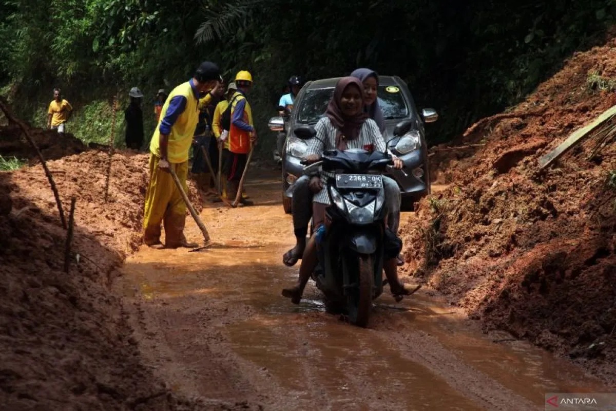Kendaraan roda dua dan roda empat melintasi jalan yang sudah dibersihkan petugas pascalongsor di akses Jalan Raya Sigaranten, Kabupaten Sukabumi, Jawa Barat, Minggu (8/12/2024). (ANTARA FOTO)