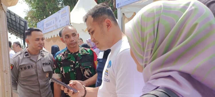 BORONG PRODUK UMKM: Pinca BRI Cibadak, Yoga Setyawan didampingi istri tercinta yang juga Ketua IWABRI membeli produk UMKM binaan BRI dan langsung melakukan payment dengan QRIS BRI. (sri/radarsukabumi)