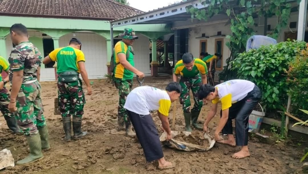 PEDULI : Para anggota Yonarmed 13 Kostrad, saat mengevakuasi material lumpur akibat banjir yang melanda dua desa di Kecamatan Pabuaran, Kabupaten Sukabumi.(FOTO : UNTUK RADAR SUKABUMI)