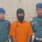 Tersangka pelaku pembunuhan Kesia Irena Yola Lestaluhu dikawal dua personel Pomal Lantamal XIV Sorong di Kota Sorong (15/1/2025). (Yuvensius Lasa Banafanu)