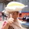 Seorang ibu menjunjung bantuan pangan beras 10 kilogram (kg) sambil mengacungkan jempol. (Humas Bapanas)