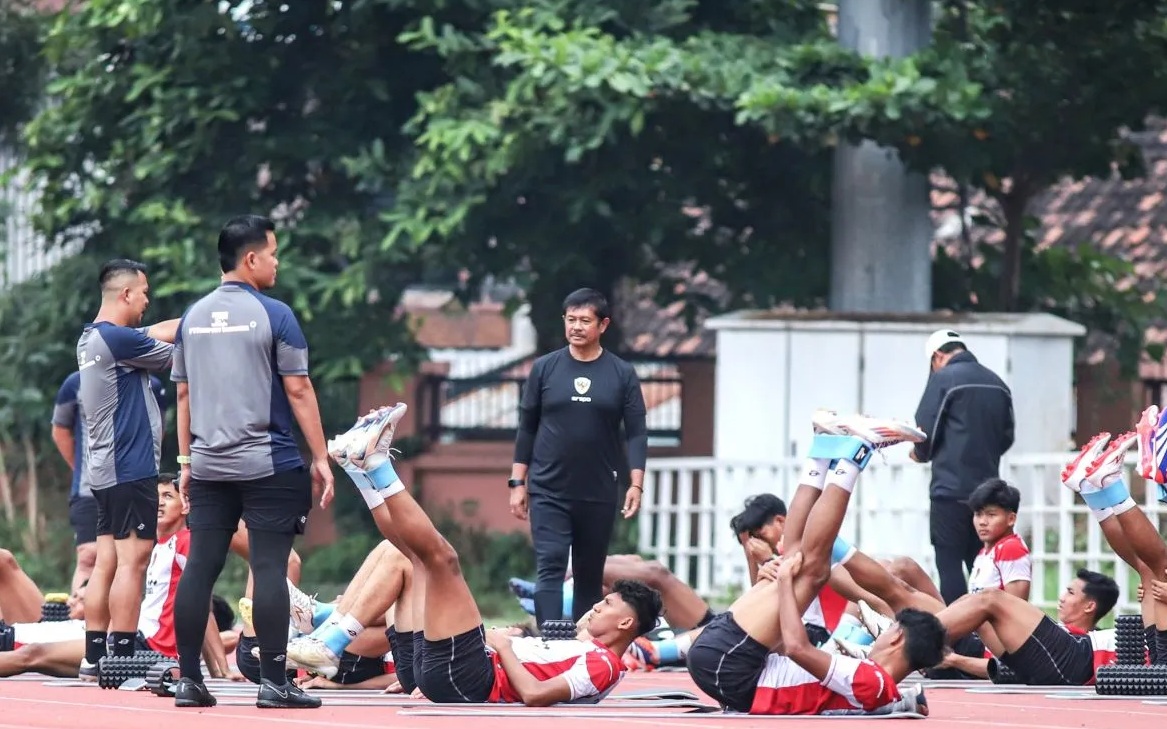 Pelatih Timnas Indonesia U-20 Indra Sjafri (tengah) mengawasi pemainnya saat melakukan pemanasan di Lapangan THOR Surabaya, Kamis (23/1/2025). (Rizal Hanafi)