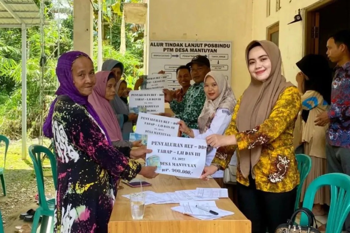 Pendamping Lokal Desa (PLD) Mantuyan Sri Laraswati (kanan) saat menyerahkan penyaluran BLT-DD kepada seorang warga Desa Mantuyan, Kecamatan Halong, Kabupaten Balangan, Kamis (16/3/2023).