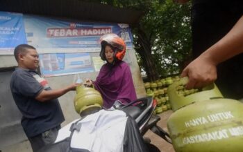 Warga menujukkan KTP nya saat membeli LPG 3 kg di pangkalan LPG di kawasan Pasar Rebo, Jakarta Timur, Selasa (2/1/2024).