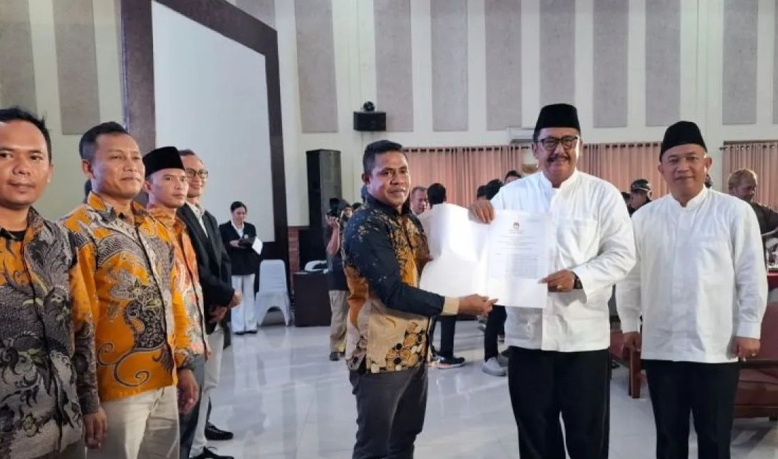 Ketua KPU Kabupaten Sukabumi menyerahkan SK KPU Kabupaten Sukabumi tentang penetapan Kepala Daerah Kabupaten Sukabumi terpilih periode 2025-2030 kepada pasangan Bupati-Wabup Sukabumi terpilih Asjap-Andreas 