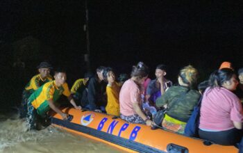 DIEVAKUASI : Petugas Yonarmed 13/Nanggala Kostrad, saat mengevakuasi korban banjir di Perumahan Pratama Indah Residence, tepatnya di Kampung Sumur Tujuh, RT 06/RW 05, Desa Bojong, Kecamatan Cikembar, Kabupaten Sukabumi pada Jumat (07/03).(FOTO : UNTUK RADAR SUKABUMI)