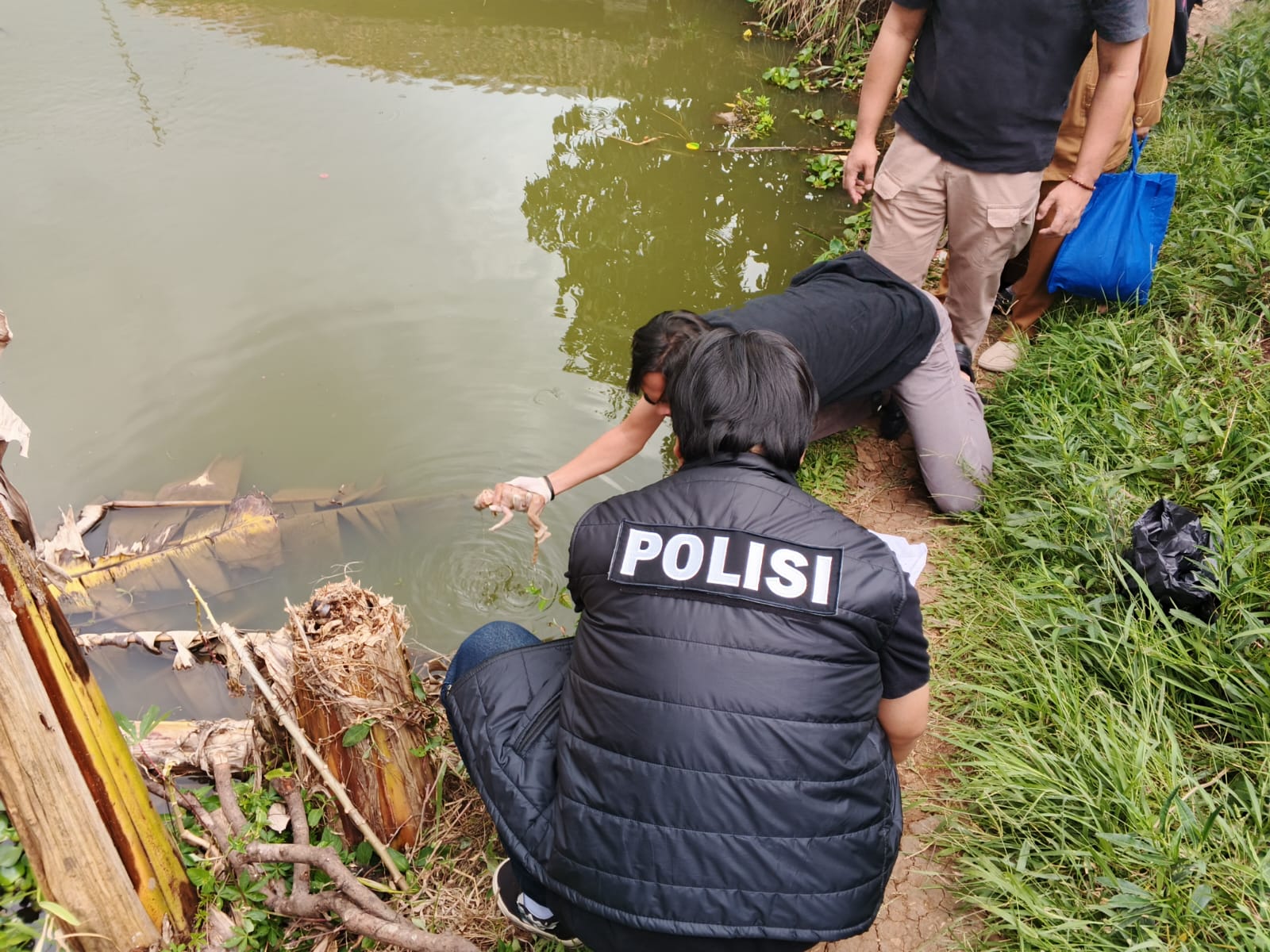 DIEVAKUASI : Petugas Polres Sukabumi Kota, saat mengevakuasi mayat bayi yang ditemukan terapung di kolam milik warga Kampung Gentong, RT 28/RW 10, Desa Selajambe, Kecamatan Cisaat, Kabupaten Sukabumi pada Senin (24/03) siang.(FOTO : UNTUK RADAR SUKABUMI)