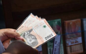 Penjual jasa penukaran uang baru menata uang di Kota Madiun, Jawa Timur, Minggu (31/3/2024).