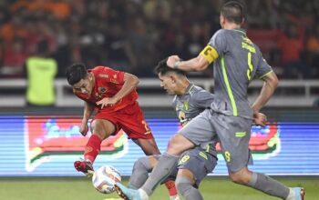 Pesepak bola Persija Jakarta Ilham Rio Fahmi (kiri) menendang bola dengan dihadang Pesepak bola Persebaya Surabaya Bruno Moreira (tengah) dan Dusan Stevanovic (kanan) dalam lanjutan Liga 1 di Stadion Utama Gelora Bung Karno (SUGBK), Senayan, Jakarta, Minggu (30/7/2023).
