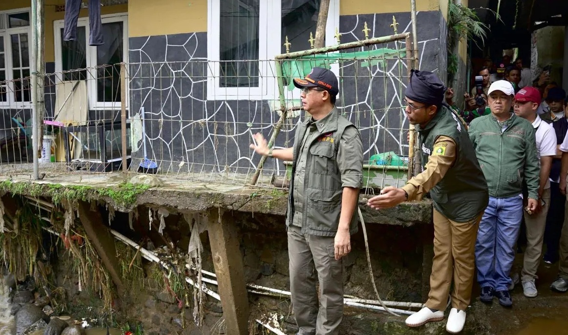 Kepala BNPB Suharyanto meninjau lokasi jembatan yang amblas terdampak banjir bandang di Desa Tugu Selatan, Kecamatan Cisarua, Kabupaten Bogor, Jawa Barat, Senin (3/3/2025). (BNPB)
