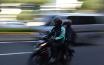 Pengendara ojek daring membawa penumpang di kawasan Mampang Prapatan, Jakarta, Selasa (11/3/2025). 