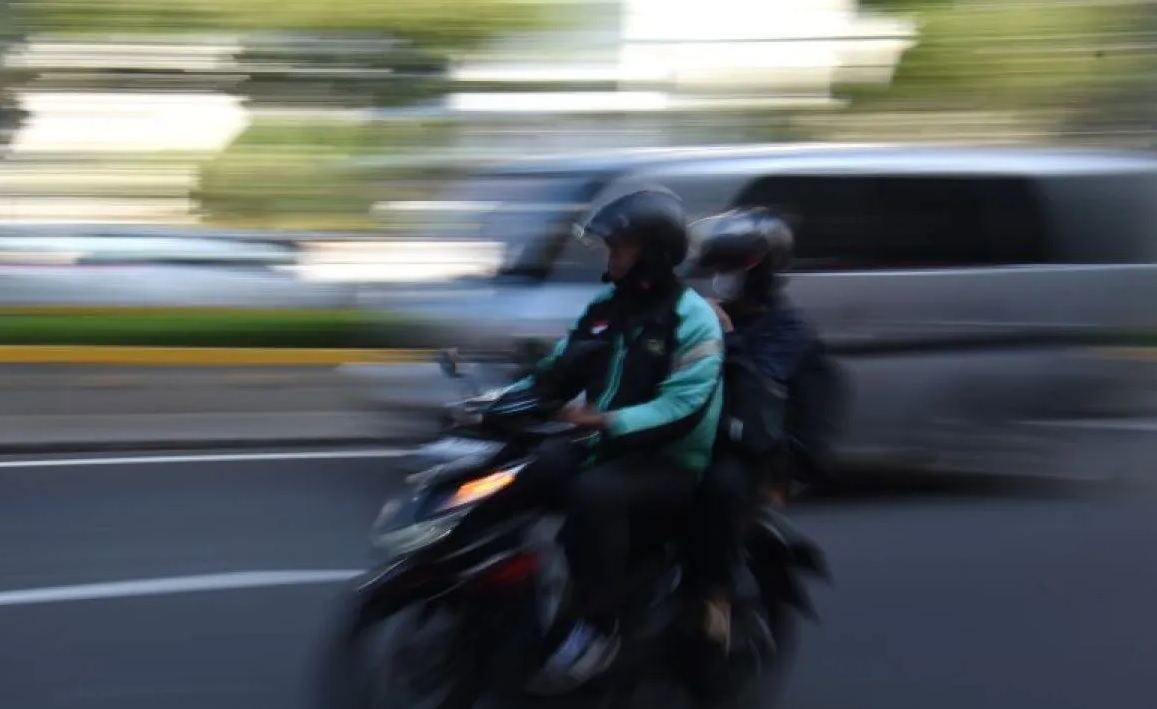 Pengendara ojek daring membawa penumpang di kawasan Mampang Prapatan, Jakarta, Selasa (11/3/2025). 