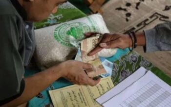 Petugas panitia amil zakat menerima uang tunai dari warga pembayar zakat fitrah. (ANTARA/Makna Zaezar/dok)
