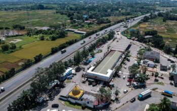 Foto udara kendaraan melintas di samping Rest Area KM 43, Balaraja, Kabupaten Tangerang, Jumat (21/3/2025). Menjelang arus mudik Lebaran, rest area yang berada di ruas Tol Tangerang - Merak tersebut mulai mendirikan fasilitas pos pengamanan, posko mudik, kantung parkir truk dan Stasiun Pengisian Kendaraan Listrik Umum (SPKLU).