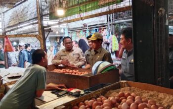 Kepala Dinas Peternakan Kabupaten Sukabumi, Drh. Asep Kurnadi, saat mendampingi Sekda Kabupaten Sukabumi, Ade Suryaman, untuk memastikan harga dan stok telur ayam di Pasar Parungkuda.