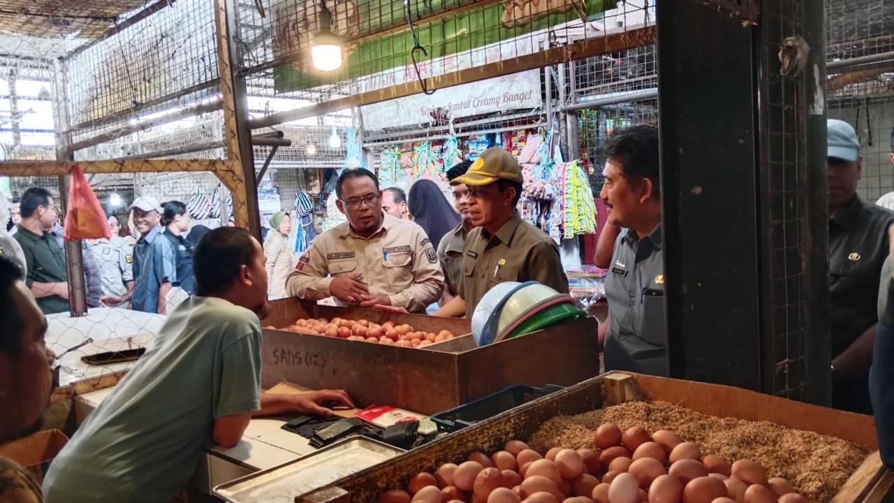 Kepala Dinas Peternakan Kabupaten Sukabumi, Drh. Asep Kurnadi, saat mendampingi Sekda Kabupaten Sukabumi, Ade Suryaman, untuk memastikan harga dan stok telur ayam  di Pasar Parungkuda. 