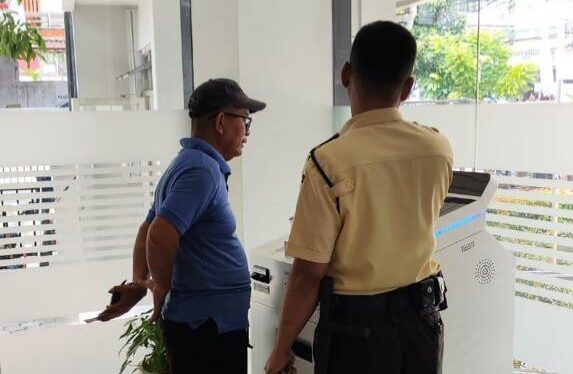 petugas satpam BRI yang siap sedia untuk membantu para nasabah yang ingin melakukan transaksi menggunakan Digital CS.