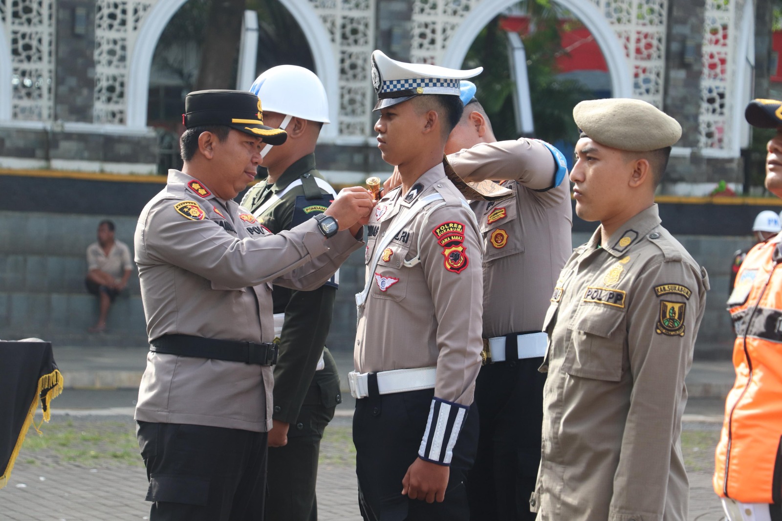 Kapolres Sukabumi AKBP Dr. Samian saat menyematkan pita tanda operasi ketupat Lodaya 2025 kepada perwakilan instansi yang terlibat.(FOTO : NANDI/ RADARSUKABUMI)