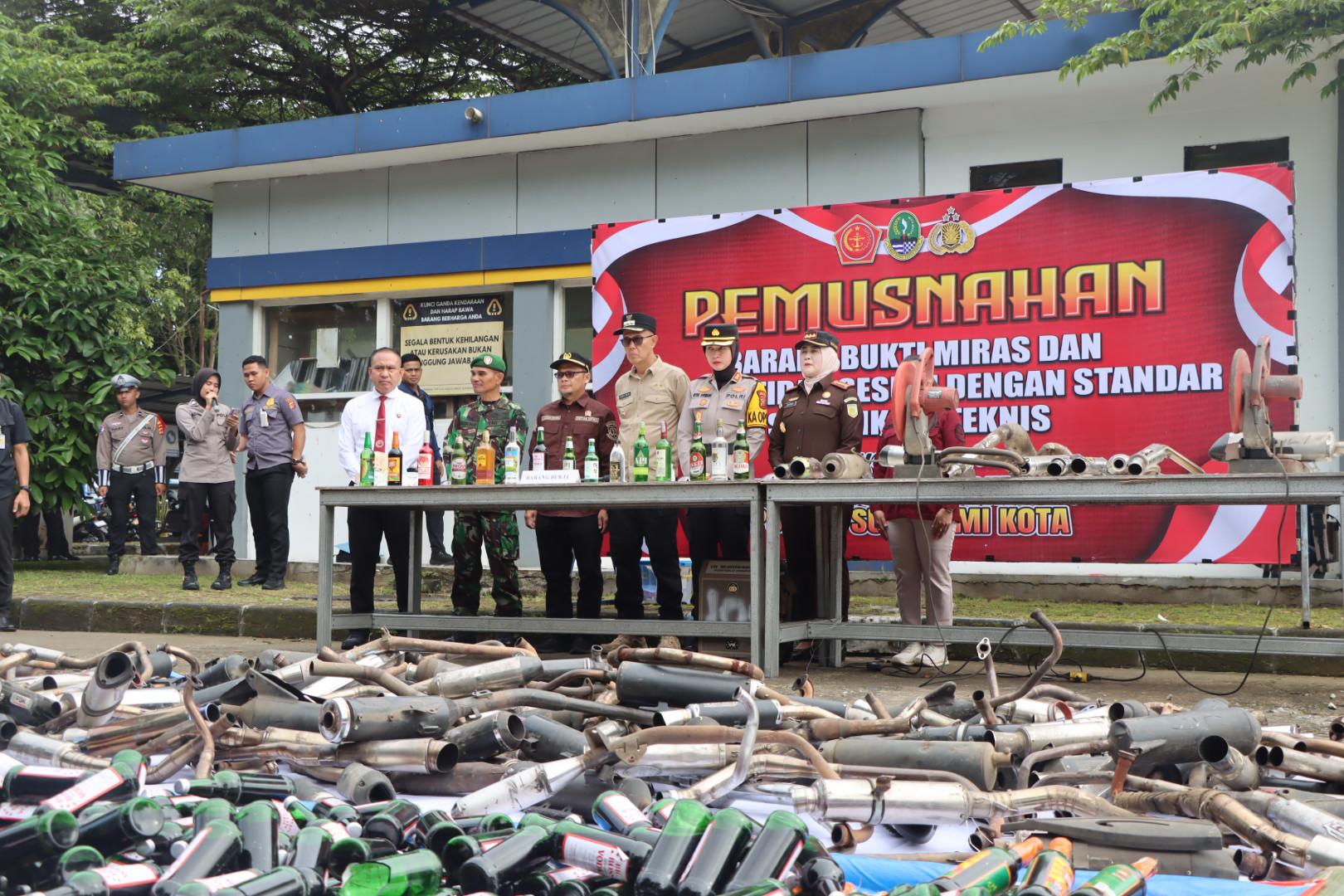 PEMUSNAHAN: Polres Sukabumi Kota bersama unsur Forkopimda memusnahkan barang bukti ribuan botol Miras berbagai merek hingga knalpot brong di Terminal Tipe A, Kamis (20/3).(FT: IST)