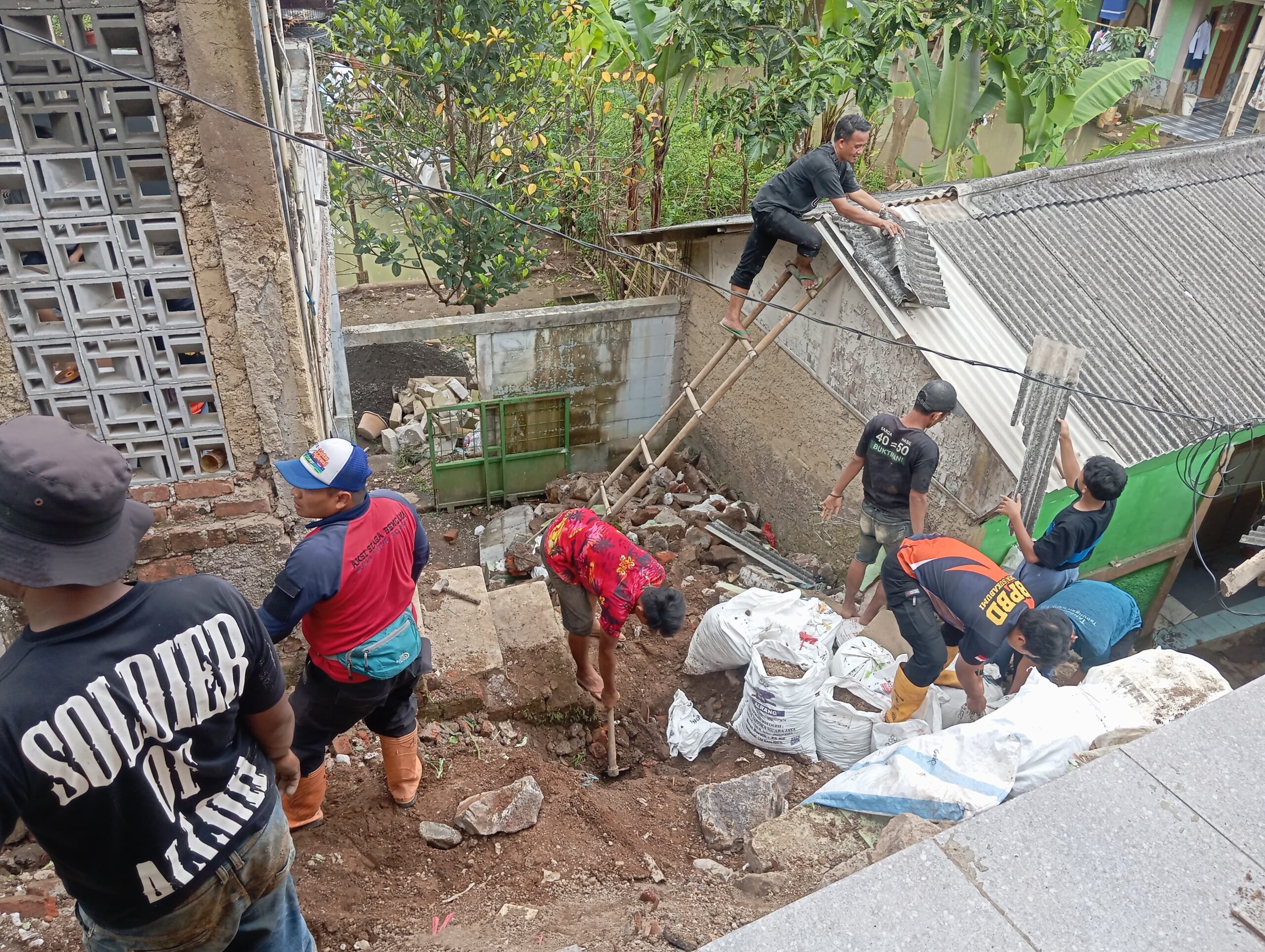 EVAKUASI: Sejumlah warga Kampung Tegalwangi RT 4/RW2, Kelurahan Sukakarya, Kecamatan Warudoyong, saat membersihkan material dinding rumah yang roboh tergerus longsor, Minggu (2/3). (FT: IST)