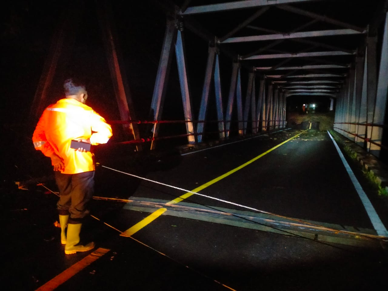 DITINJAU : Petugas BPBD Kabupaten Sukabumi, saat asessment di lokasi bencana Jembatan Bojong Kopo Sungai Cidadap, Kecamatan Simpenan pada Jumat (07/03).(FOTO : UNTUK RADAR SUKABUMI)
