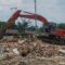 Alat berat melakukan upaya pembongkaran jembatan yang melintasi sungai Cipalabuan akses warga menuju area Dermaga PPN Palabuhanratu. Minggu (9/3/2025).(FOTO : NANDI/ RADARSUKABUMI)