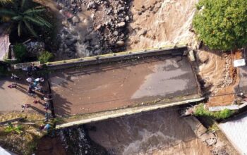 Foto udara kondisi jembatan Ciliwung yang putus akibat meluapnya sungai Ciliwung di Desa Jogjogan, Cisarua, Kabupaten Bogor, Jawa Barat. (Yulius Satria Wijaya)
