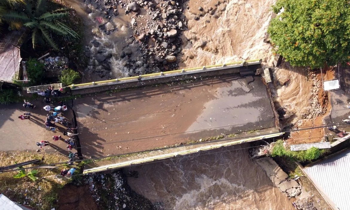 Foto udara kondisi jembatan Ciliwung yang putus akibat meluapnya sungai Ciliwung di Desa Jogjogan, Cisarua, Kabupaten Bogor, Jawa Barat. (Yulius Satria Wijaya)