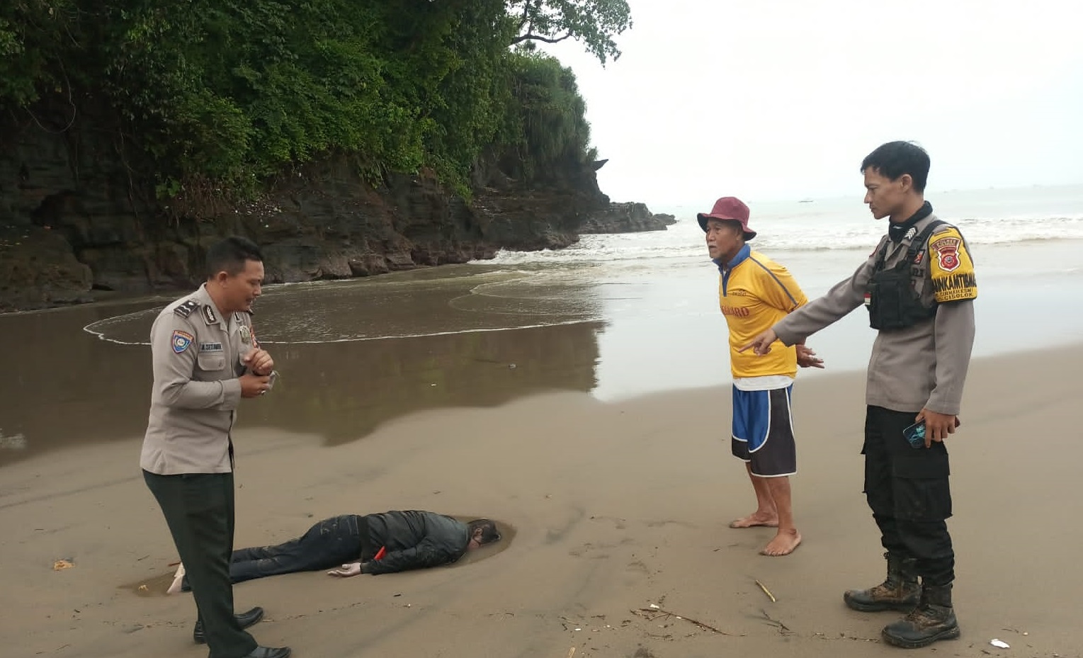 Personel kepolisian saat melakukan pengecekan terhadap mayat pria di sekitar pantai Kebon Kalapa, Desa/ Kecamatan Cisolok, kabupaten Sukabumi. Senin (10/3/2025).(FOTO : NANDI/ RADARSUKABUMI)
