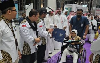 Petugas Penyelenggara Ibadah Haji (PPIH) Arab Saudi saat memberikan salam perpisahan kepada jamaah haji embarkasi Kertajati kelompok terbang 30 (KJT-30) yang menjadi kloter terakhir yang dipulangkan ke Indonesia.