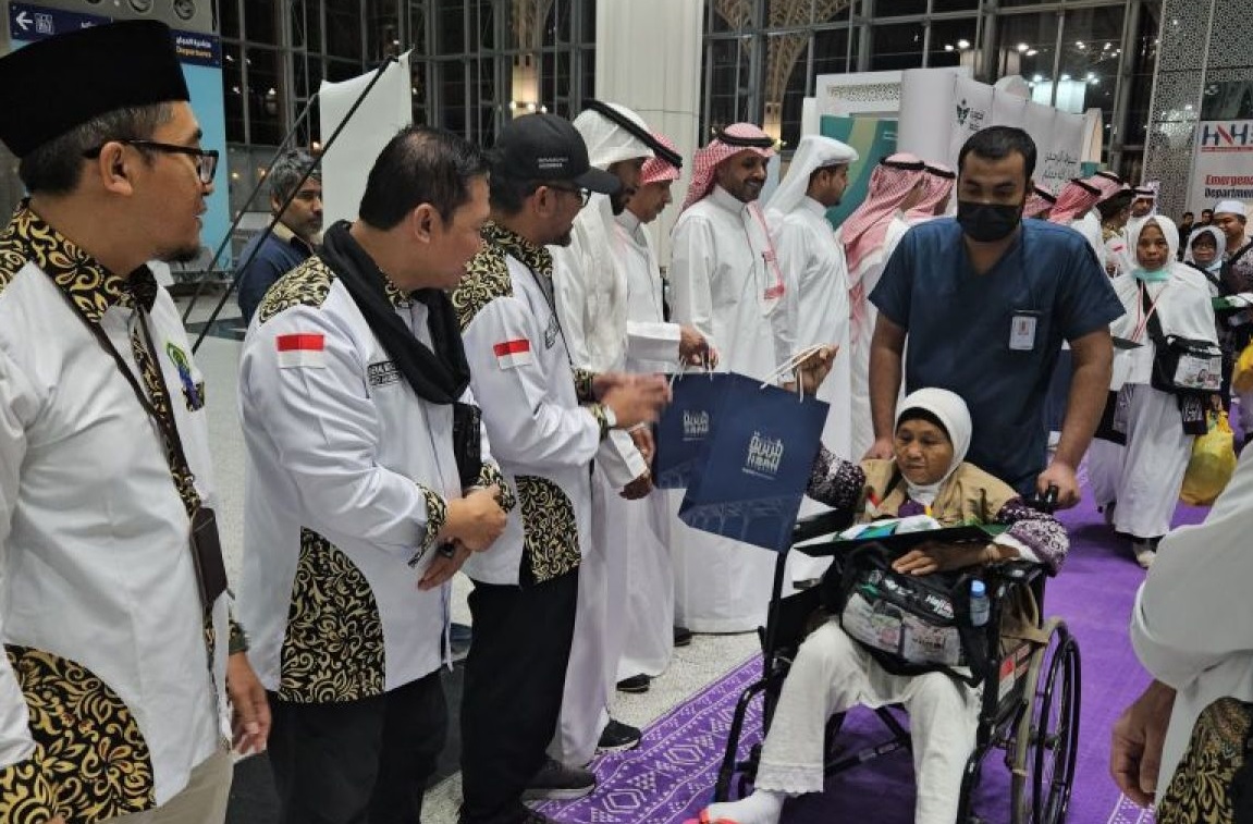Petugas Penyelenggara Ibadah Haji (PPIH) Arab Saudi saat memberikan salam perpisahan kepada jamaah haji embarkasi Kertajati kelompok terbang 30 (KJT-30) yang menjadi kloter terakhir yang dipulangkan ke Indonesia.