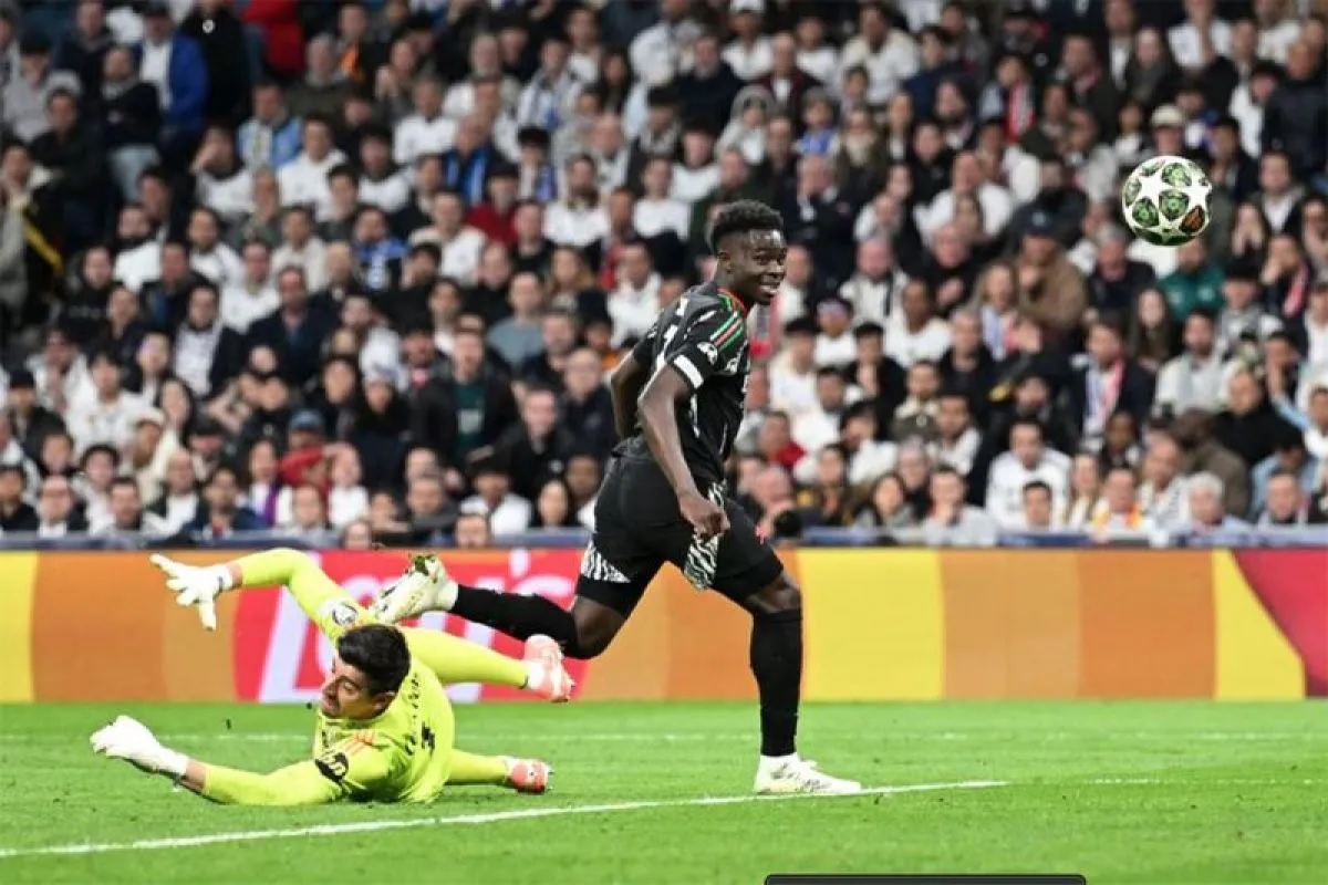 Pemain Arsenal,Bokayo Saka (kanan), melawati penjaga gawang Real Madrid,pada leg kedua perempat final Liga Champions di Stadion Santiago Bernabeu, Madrid, Kamis dini hari WIB (17/4/2025). (www.arsenal.com)