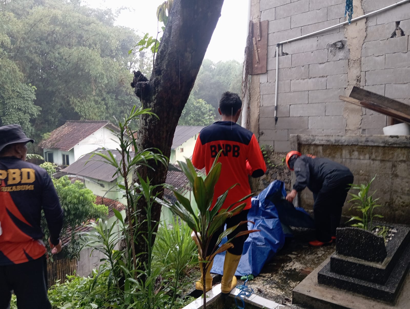 PENANGANAN: Sejumlah petugas BPBD Kota Sukabumi saat melakukan pemasangan terpal untuk mencegah longsor susulan di Kampung RT2/1 Kelurahan Karangtengah, Kecamatan Gunungpuyuh, Selasa (15/4). (FT: IST)