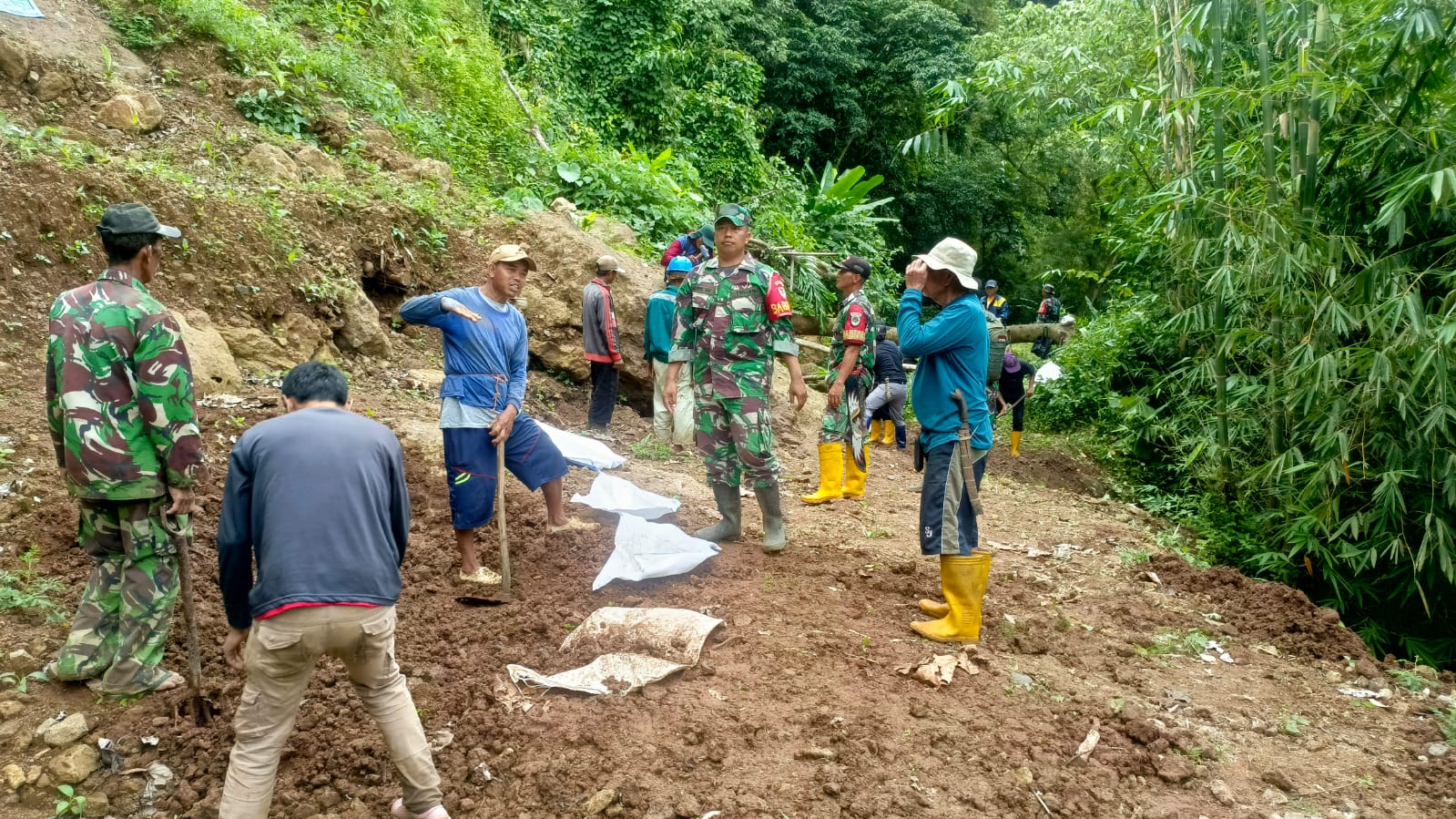 DIPERBAIKI : Petugas TNI bersama warga saat gotong royong memperbaiki saluran irigasi di Desa Cimanggu, Kecamatan Cikembar, Kabupaten Sukabumi, pada Senin (21/04/2025).