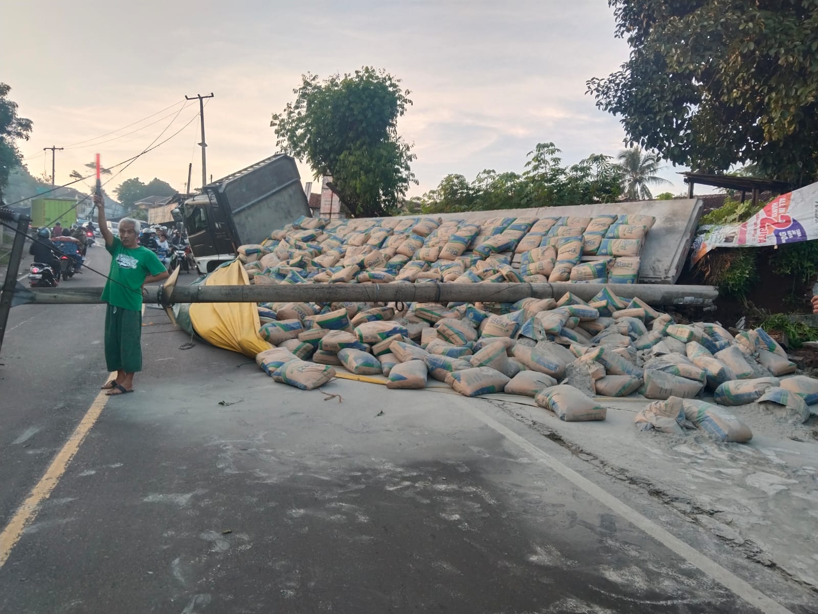 DIEVAKUASI : Petugas Polres Sukabumi, saat hendak mengevakuasi truk muatan semen yang terjungkal di ruas Jalan Raya Sukabumi - Bogor, tepatnya di Kampung Pondok Leungsir, RT 020/RW 006, Desa Cicande, Kecamatan Cicantayan, Kabupaten Sukabumi pada Minggu (27/04) pagi.(FOTO : UNTUK RADAR SUKABUMI)