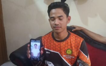 Kakak Kandung Dandi saat menunjukan foto Cahya adiknya di ponsel