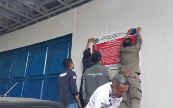 DITUTUP : Tim gabungan saat melakukan pemasangan segel bangunan mewah di kampung Cibolang, Desa Citepus, Kecamatan Palabuhanratu, Kabupaten Sukabumi.(FOTO : NANDI/ RADARSUKABUMI)