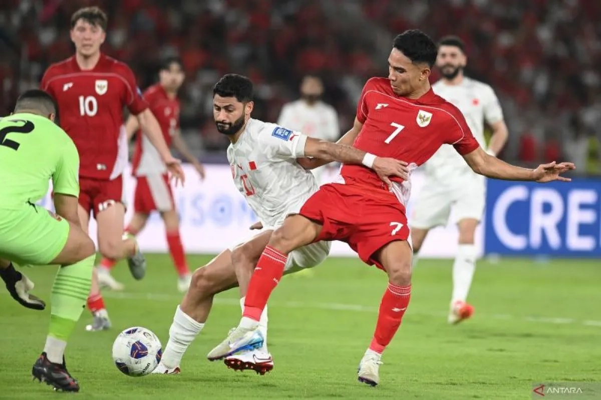 Pesepak bola Timnas Indonesia Marselino Ferdinan (kanan) berebut bola dengna pesepak bola Timnas Bahrain Ahmed Bughammar (tengah) dalam pertandingan Grup C putaran ketiga Kualifikasi Piala Dunia 2026 zona Asia di Stadion Utama Gelora Bung Karno, Senayan, Jakarta, Selasa (25/3/2025). (Muhammad Adimaja/sgd)