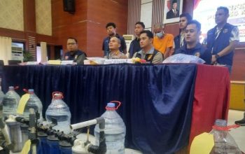 Kapolres Metro Bekasi Komisaris Pol. Mustofa memeriksa tutup palsu galon hasil pengungkapan pemalsu air siap minum di Mapolres Metro Bekasi, Jumat (23/5/2025). (Pradita Kurniawan Syah)