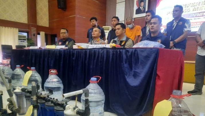 Kapolres Metro Bekasi Komisaris Pol. Mustofa memeriksa tutup palsu galon hasil pengungkapan pemalsu air siap minum di Mapolres Metro Bekasi, Jumat (23/5/2025). (Pradita Kurniawan Syah)