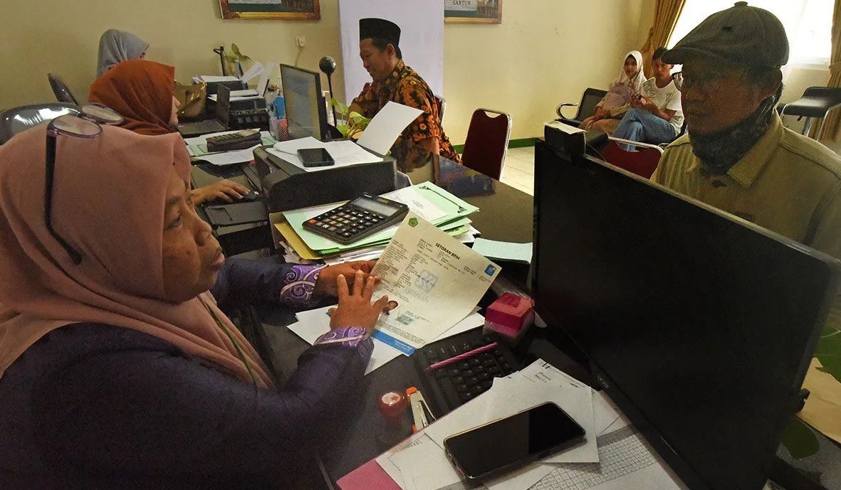 Warga calon jamaah haji menanyaan kepastian waktu keberangkatan kepada Petugas Kantor Kementrian Agama Kota Serang, Banten, Kamis (16/2/2023). (Asep Fathulrahman)