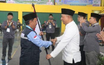 DIBERANGKATKAN : Wakil Bupati Sukabumi, Andreas saat menyerahkan bendera merah putih kepada Ketua Kloter 18 Lukman Hakim di Komplek Pusbangdai Cikembang, Desa Sukamulya, Kecamatan Cikembar, Kabupaten Sukabumi pada Jumat (9/5) siang.(FOTO : UNTUK RADAR SUKABUMI)