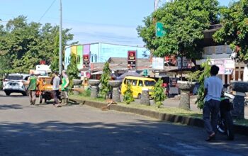 Personel Disperkim saat membersihkan rumput di ruas jalan Raya Jenderal Sudirman, Kelurahan/Kecamatan Palabuhanratu.(FOTO : NANDI/ RADARSUKABUMI)