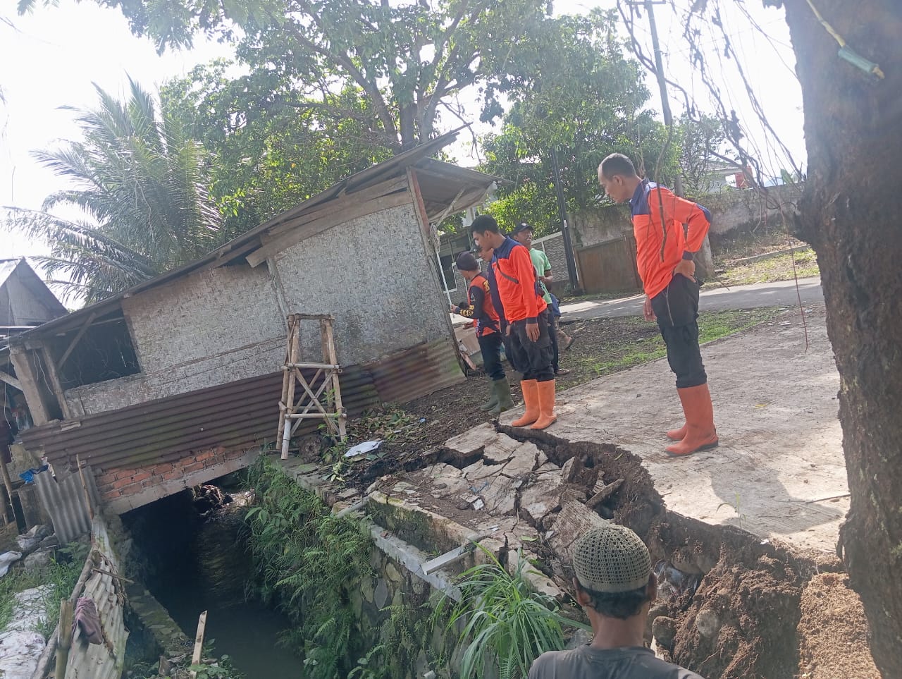 PENINJAUAN: Sejumlah personel BPBD Kota Sukabumi saat melakukan peninjauan TPT ambruk di Jalan Cikaret RT3/RW7, Kelurahan Babakan, Kecamatan Cibeureum, Minggu (25/5).