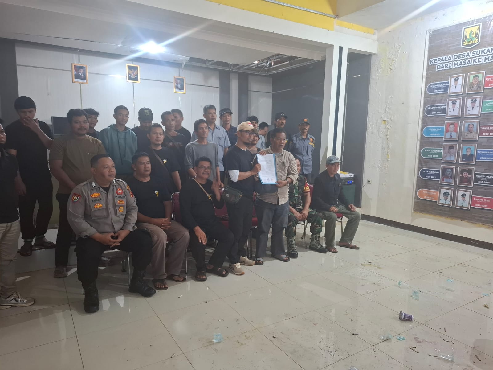 MENUNTUT : Salah seorang warga saat menyampaikan tuntutan dalam audiensi di aula kantor Desa Sukamulya, Kecamatan Cikembar, Kabupaten Sukabumi, pada Sabtu (24/05). (FOTO : UNTUK RADAR SUKABUMI)