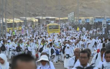Jamaah haji dari berbagai negara termasuk Indonesia berjalan kaki di samping deretan bus yang tidak bisa bergerak karena terjebak kemacetan di Muzdalifah, Makkah, Arab Saudi, Jumat (6/6/2025).