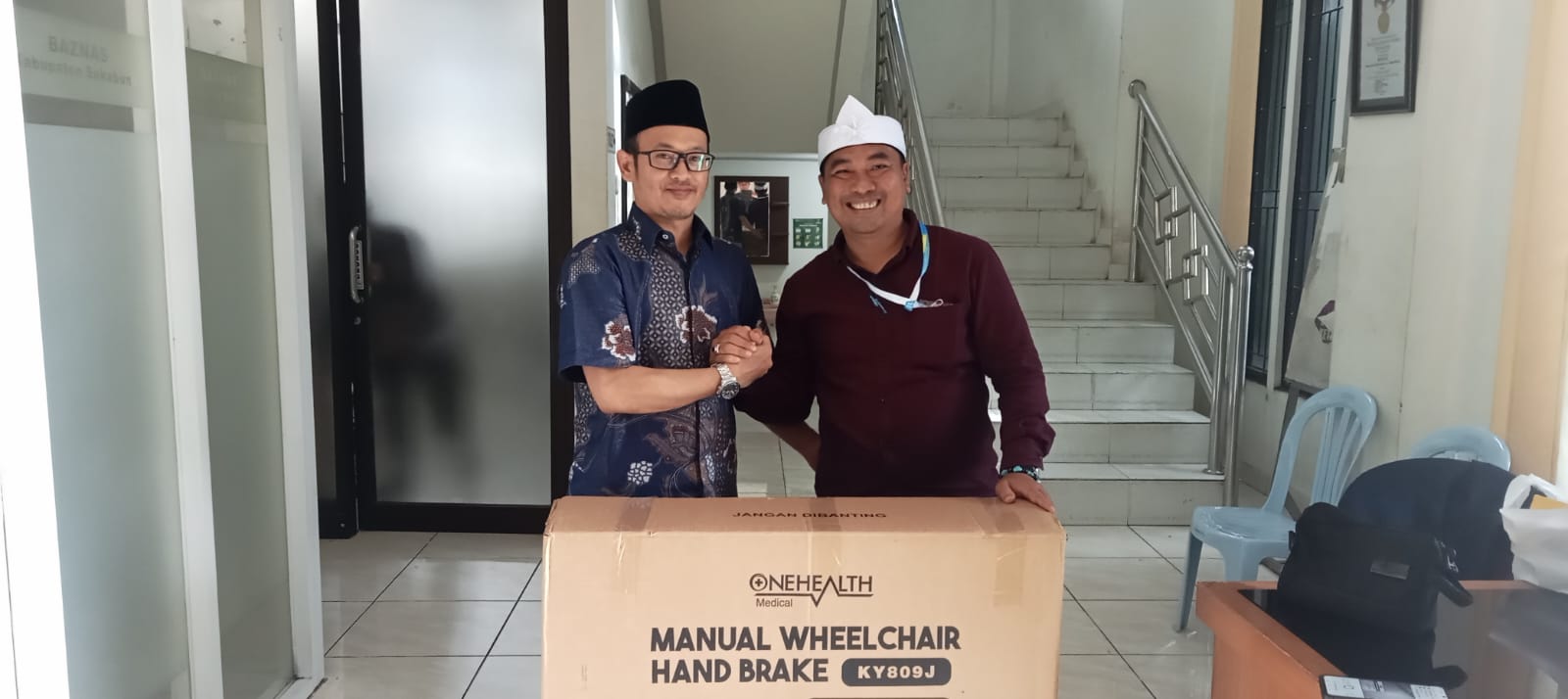 PEDULI : Kepala Divisi Pendistribusian dan Pendayagunaan Baznas Kabupaten Sukabumi, Muhammad Kamaludin saat memberikan bantuan kursi roda kepada Kades Kebonpedes, Dadan Aprinda, belum lama ini.