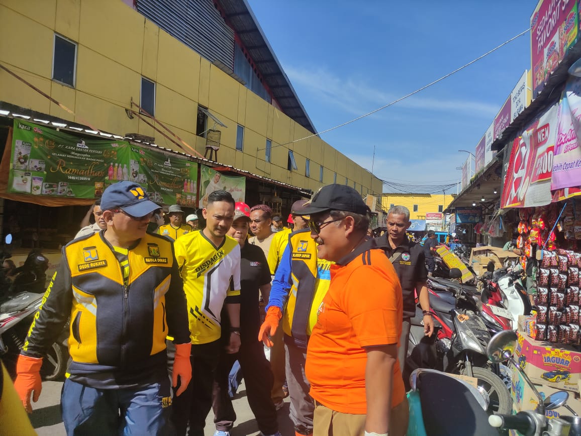 DIBERSIHKAN : Bupati Sukabumi, Asep Japar didampingi Kadisdagin Kabupaten Sukabumi, Dani Tarsoni saat hendak membersihkan sampah di pasar Cisaat.